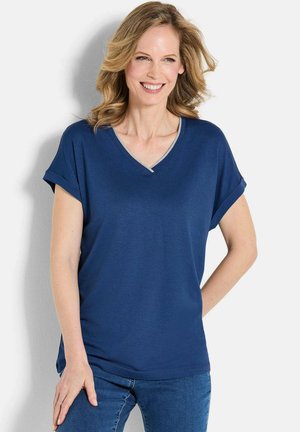 Maglietta blu navy con scollatura a V e maniche corte arrotolate, realizzata in un tessuto liscio. Presenta un bordo a contrasto, di colore più chiaro, lungo il collo.