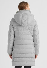 Helle graue Daunenjacke mit Kapuze, vertikalen Streifen, hohem Kragen und gerippten Bündchen. Strukturierter Stoff mit gesteppter Optik.