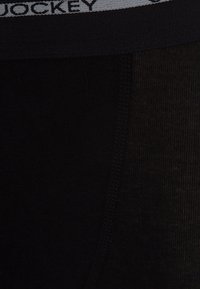 Sorte boxerbriefs med tekstureret stof, med en kontrasterende grå talje, hvor brandnavnet "Jockey" er vævet i sort.