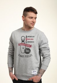 Šedá mikina s potiskem bowlingu a textem "American Bowling Congress Champions 1961" a štítkem "Park Fields" na lemu.