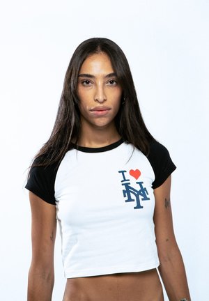 Camiseta corta de manga corta en blanco y negro. Presenta un corazón rojo y un gráfico azul "I NY" en el frente. Material de algodón suave.