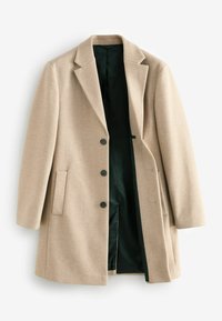 Beige uldfrakke med skræddersyet design, enkeltknappet foran, tre sorte knapper og grøn foret. Har sidelommer og slag.