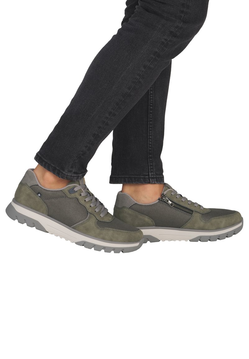 Grüne Wildleder- und Mesh-Turnschuhe mit grauer Gummisohle. Verfügen über Schnürsenkel und einen seitlichen Reißverschluss sowie strukturierte Details am Obermaterial.