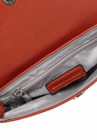 Red leather handbag interior with a gray lining, featuring a zippered pocket and a brand label. Smooth texture and minimal hardware details.
