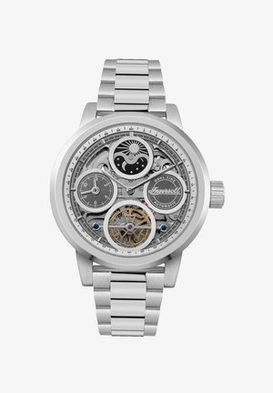 Zilveren roestvrijstalen horloge met een skeletonized wijzerplaat, dual time display, ingewikkelde tandwielen en een gestructureerde metalen armband.
