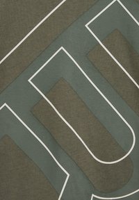 Tamsiai alyvuogių spalvos audinys su baltu geometriniu raštu. Yra persidengiančių formų su kontrastingomis tekstūromis ir lygiomis kontūromis.
