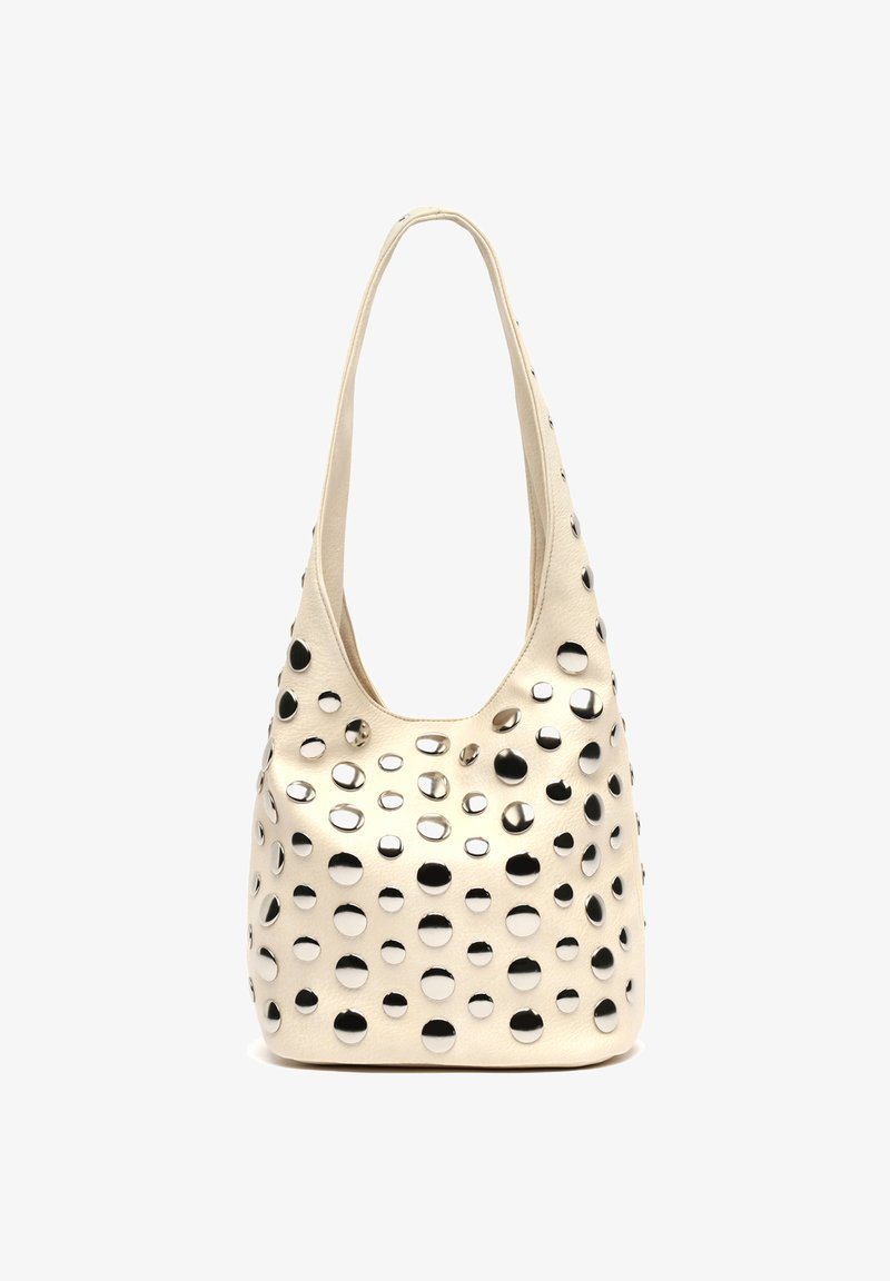 Kremowa skórzana torba na ramię z równomiernie rozmieszczonymi srebrnymi okrągłymi ćwiekami pokrywającymi zewnętrzną część oraz pojedynczym długim uchwytem.