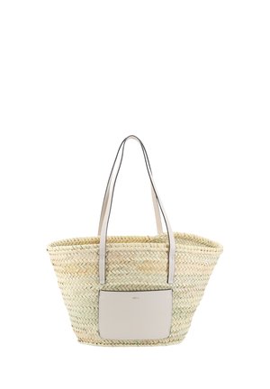 Woven straw tote bag with long beige leather handles and a beige front pocket, set against a white background.