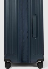 Navyfarbener Hartschalenkoffer mit vertikalen Rillen, strukturiertem Stoffabdeckungsreißverschluss und vier multidirektionalen Rollen für eine einfache Handhabung.