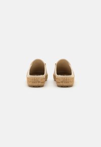 Bežne slip-on čevlje z espadrilno podplatom. Tekstilni zgornji del s tkanimi detajli in strukturiranim juto robom okoli podplata. Oblika z odprtim hrbtom.