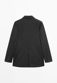 Zwart, op maat gemaakte blazer met lange mouwen, knoopmanchetten en een centrale achtersplit, gezien van achteren tegen een witte achtergrond.