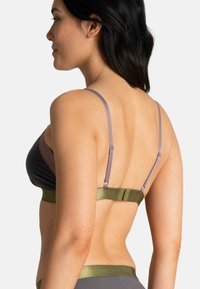 Soutien-gorge avec un design triangulaire noir, des accents en dentelle marron, des bretelles lilas et une bande inférieure verte olive.