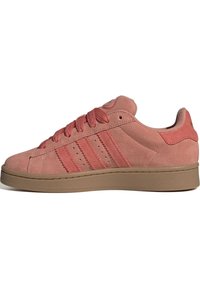 Südfärgad rosa sneakers med rund tå, snörning och tre sidosträck. Har en brun gummisula och mjuka tygdetaljer.