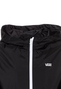 Czarna lekka kurtka przeciwwiatrowa z białym zamkiem i logo. Posiada kaptur oraz gładką, lekko połyskującą teksturę.