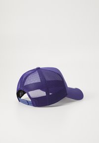 Lilla kasket med net bagpå, et solidt frontpanel og justerbar rem. Har en rund skygge og diskret branding på siden.