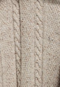 Beige gebreide trui met een gestructureerd patroon, voorzien van gedraaide kabelontwerpen en kleurspikkels door de stof heen.