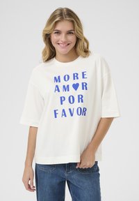 Biała bawełniana koszulka z krótkim rękawem z wyraźnym niebieskim napisem: "WIĘCEJ ❤️ AMOR POR FAVOR." Luźny krój, prosty design, miękka faktura.
