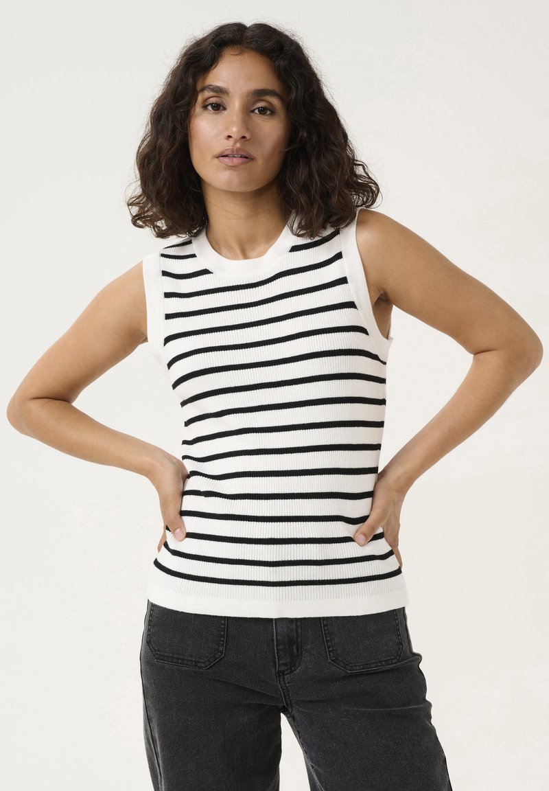 Sleeveless, ribbed knit top in white with black horizontal stripes. Features a crew neck and a fitted silhouette. Paired with black jeans.