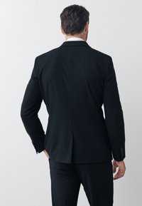 Melnas žaketes ar elegantu dizainu, ar iegrieztām atlēta malām un vienu atvērumu. Piedāvā pogas uz piedurknēm un gludu auduma faktūru.