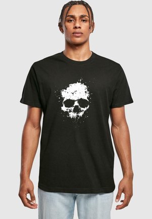 Sort bomuld t-shirt med et hvidt splatter kraniumgrafik i midten. Korte ærmer og rund hals. Ingen synlige mærkehenvisninger.