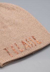 Berretto lavorato a maglia color cachi con una morbida consistenza, caratterizzato da lettere ritagliate in sughero che mostrano chiaramente la parola "CLASSIC".