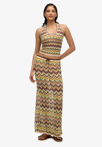 Maxi-Kleid und Crop-Top-Set im mehrfarbigen Zickzackmuster, mit passendem Halsansatz, Kordelzug in der Taille und weichem Material.