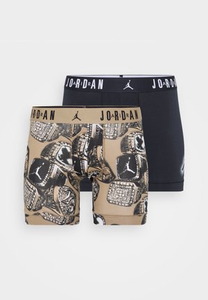 Deux paires de boxers pour hommes. L'une est noire unie ; l'autre présente un motif noir et or avec le logo Jordan et des bagues de championnat.