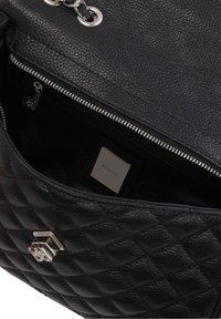 Black leather handbag with quilted texture, silver hardware, and zipper closure. Interior features a branded metal tag in a lined compartment.