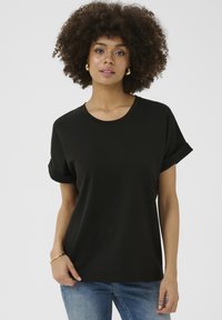 Juoda marškinėliai su trumpomis sulenktomis rankovėmis, apvaliu iškirpimu ir minkšta medžiaga. Modelis derina su šviesiai mėlynomis džinsomis. Paprastas, modernus dizainas.