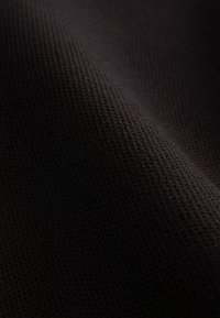 Tessuto nero testurizzato con un motivo a rete, superficie liscia e leggermente lucida; materiale flessibile e leggero.