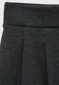 Tessuto grigio scuro a maglia con vita e pieghe morbide, suggerendo un dettaglio di gonna o pantaloni confortevole.