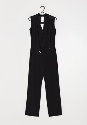 Combinaison sans manches noire avec un décolleté en V profond, des détails plissés, des poches latérales et une ceinture à nouer pour l'ajustement, fabriquée en tissu léger.