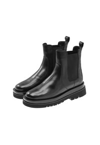 Une paire de bottines Chelsea en cuir noir avec des panneaux latéraux en elastique, des semelles en caoutchouc épaisses et des languettes à l'arrière, présentées sur fond blanc.