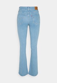 Jean en denim bleu clair avec une taille haute, deux poches arrière et des jambes légèrement évasées, vu de dos.