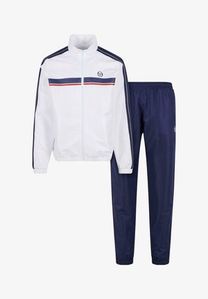 Hvit zip-jakke med marineblå og røde striper, kombinert med marineblå joggebukser med elastisk liv og ribbede anklene.