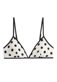 White triangle bralette with black polka dots, thin adjustable black straps, and black trim along the edges.
