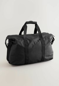 Black duffel bag made of durable, matte material with reinforced straps, zip closure, and side clip. Rectangular shape, textured finish.
