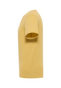 Camiseta de manga corta en algodón amarillo mostaza. Presenta un escote redondo y un corte recto con una textura suave.