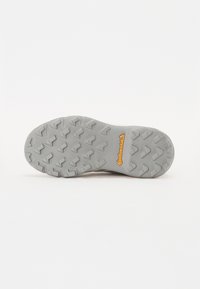 Semelle en caoutchouc gris avec des crampons multidirectionnels pour une adhérence optimale. Présente le logo "Continental" en jaune, conçu pour l'adhérence et la durabilité.