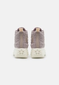 Fuzzy lila högtoppskor med en texturerad yta, som har kontrasterande beige detaljer, en stjärnformad detalj på sulan och dragflikar.