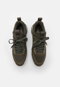 Mörkgröna nätstövlar med texturerat tyg, platta snören, förstärkt häl och vita sulor. Har en logotypetikett på tungan.