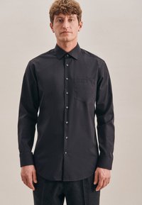 Zwarte langarmshirt van een zachte stof, met een spitsel kraag, knoopsluiting aan de voorkant, een enkele borstzak en een subtiele glans.