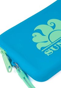 Funda de silicona azul con un logo de sol verde elevado, cierre con cremallera y tirador verde. Textura suave y bordes redondeados.