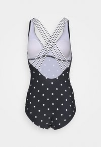 Schwarzer Badeanzug mit weißen Punkten, ausgestattet mit überkreuzten gestreiften Trägern, einer eingebauten Bruststütze und einer glatten Textur. Offenes Rückendesign.