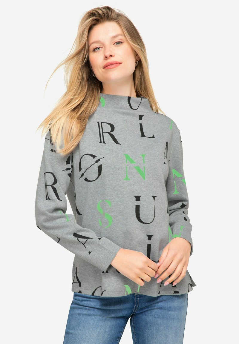 Szary sweter z wysokim kołnierzem, długimi rękawami oraz mieszaniną czarnych i zielonych liter w wzorze. Luźny krój z zaokrąglonym dołem.