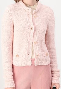 Ljusrosa stickad cardigan med texturerad yta, försedd med rund krage, guldfärgade knappar och framfickor.