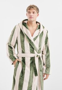 Gestreepte badjas van zacht, pluchen stof; heeft groen en lichtbeige verticale strepen, een capuchon en een strikceintuur.