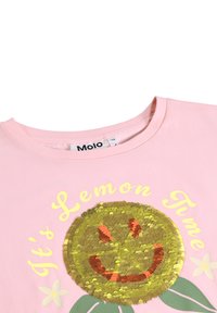 Camiseta de algodón rosa con un gráfico de cara de limón de lentejuelas doradas que sonríe, rodeado de hojas verdes y texto amarillo "Es hora de limón".