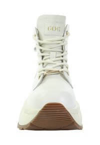 Białe botki za kostkę z białymi sznurowadłami, okrągłym noskiem, wyściełanym kołnierzem i złotym logo na języku. Teksturowana gumowa podeszwa z gumowym spodem.
