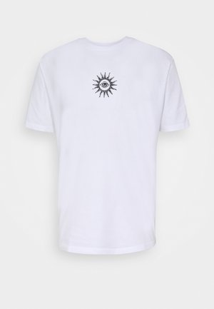 Chemise grise boutonnée, t-shirt blanc avec graphisme de soleil, short rayé gris et blanc, chaussettes blanches et baskets grises. Tenue décontractée présentée.